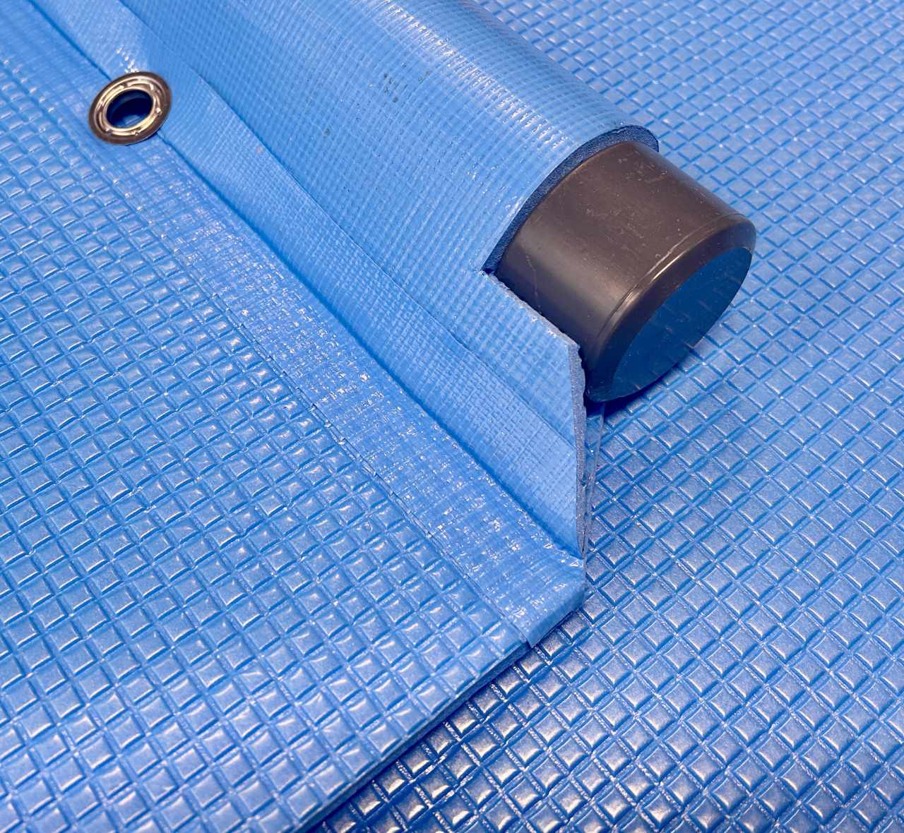 Detail van drijfbuis, eindkap, oog en afwerking van de blauwe foamafdekking van 123Dekzeilen